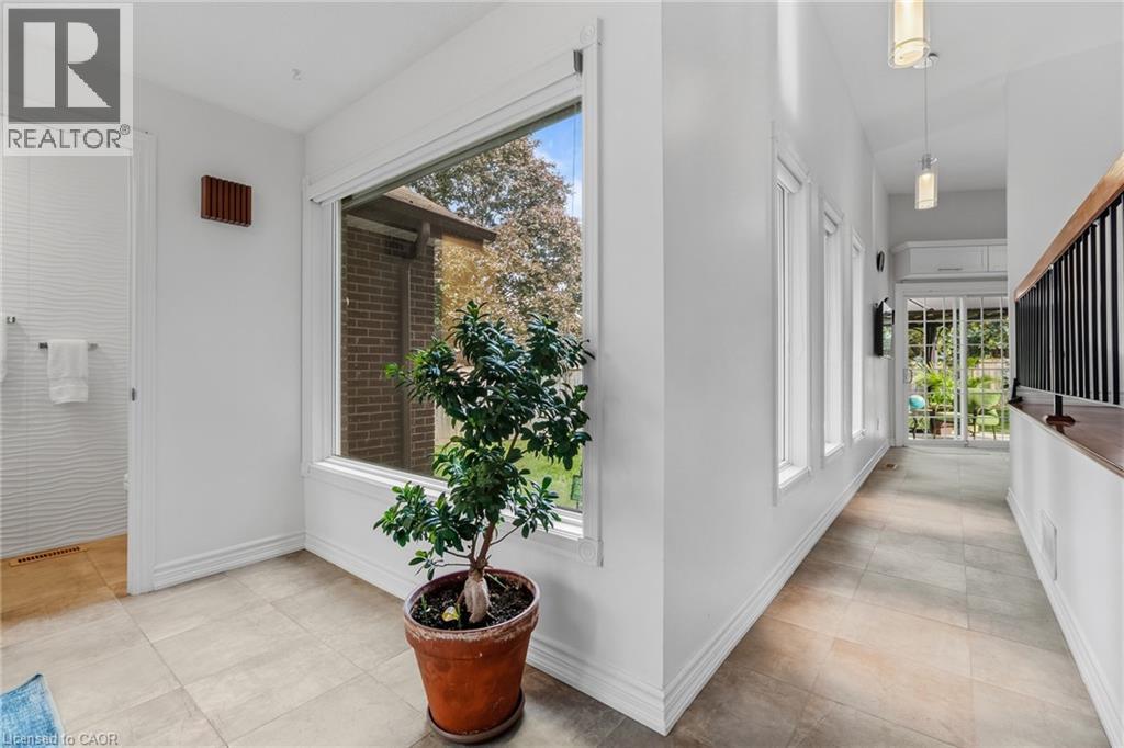 Floor-to-ceiling window, tiled flooring, built-in shelving, white walls, and a wood and metal railing