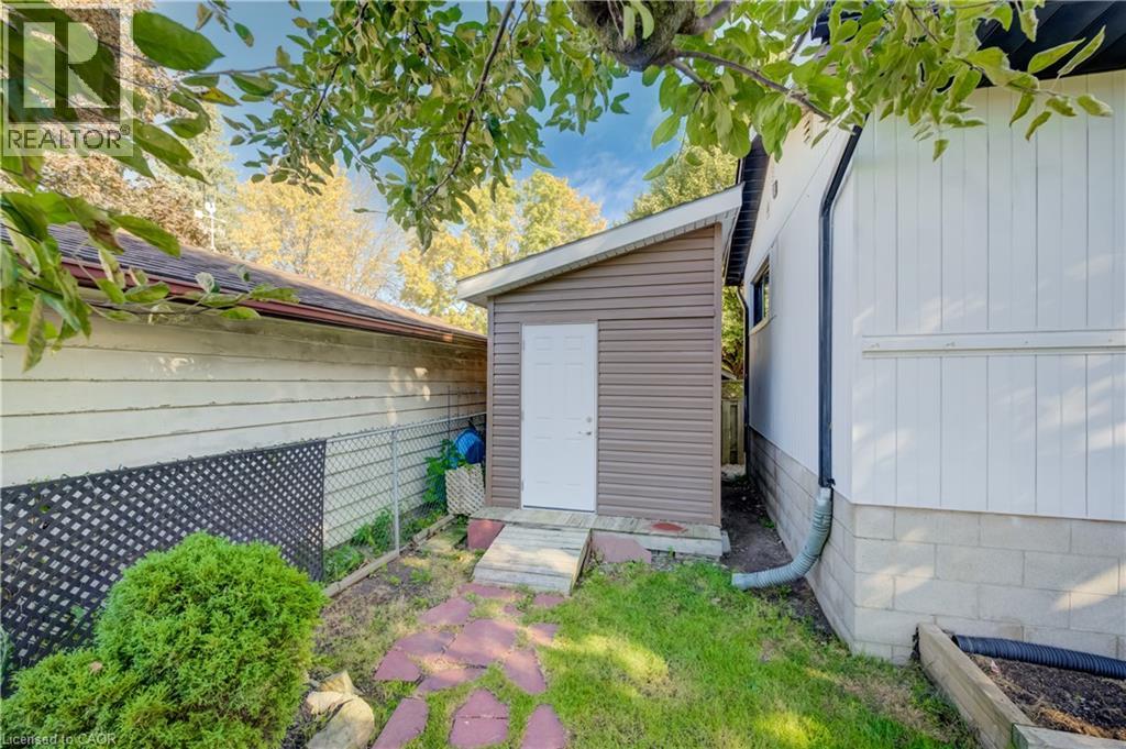 Brown vinyl-sided storage shed with a white door, set on a small concrete slab