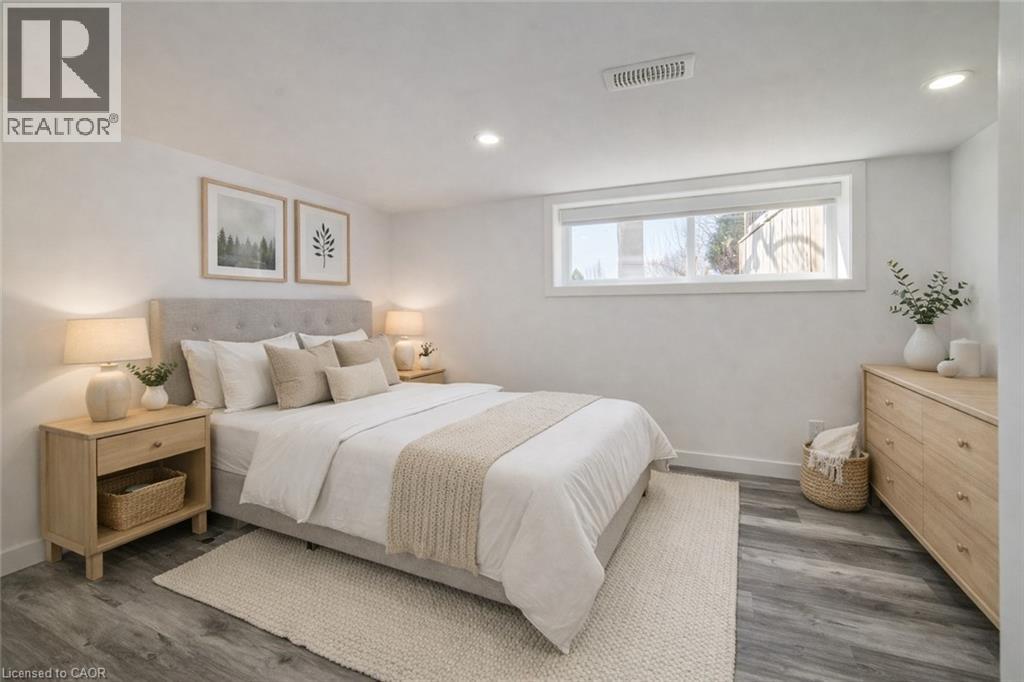 Bedroom featuring wood-finish flooring, a recessed window, and white walls
